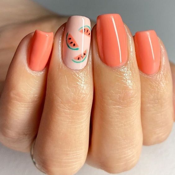 Manicura en color durazno decorada con stickers de sandía