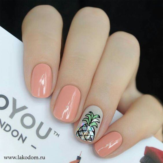 Manicura en tono rosa decorada con una piña al centro