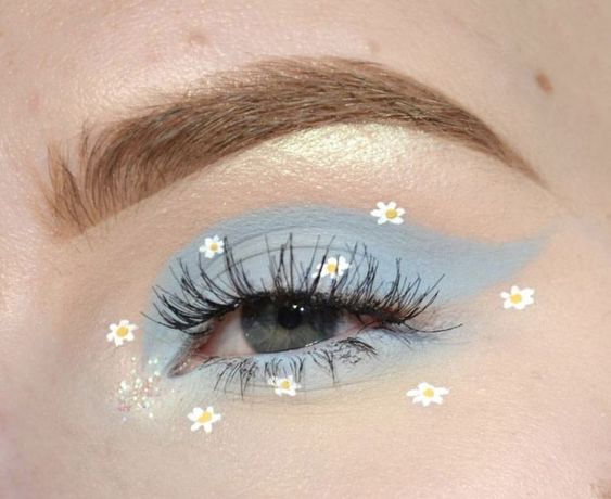 chica con sombra azul en los ojos y delineado decorativo con flores; Delineados con flores para una mirada llena de color