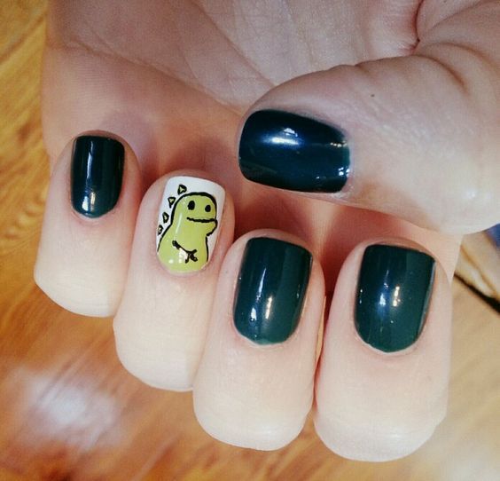 Chica con un diseño de uñas de dinosaurios en diferentes colores