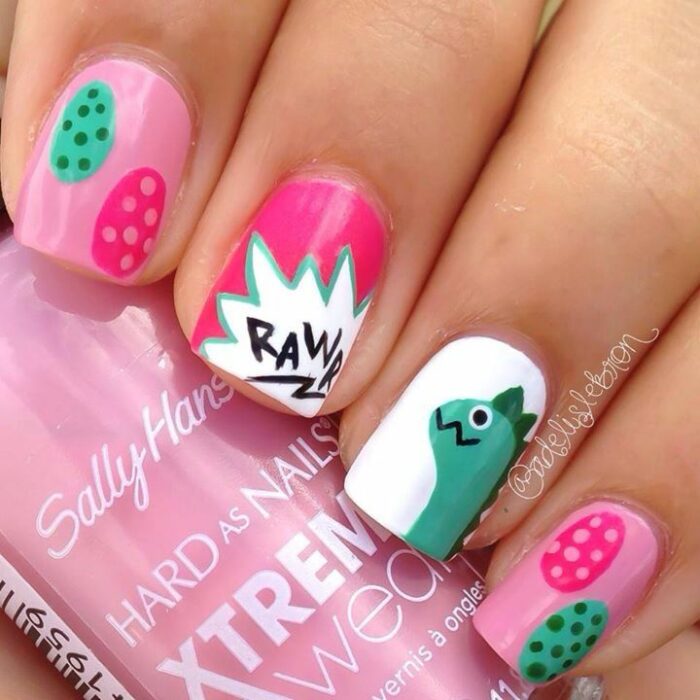 Chica con un diseño de uñas de dinosaurios en diferentes colores