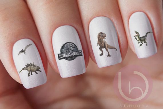 Chica con un diseño de uñas de dinosaurios en diferentes colores
