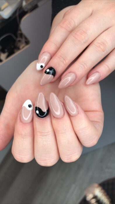 Chica mostrando sus uñas con diseño Yin Yang en color blanco, nude y negro