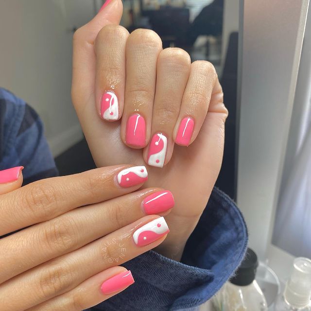 Chica mostrando sus uñas con diseño Yin Yang en color blanco con rosa
