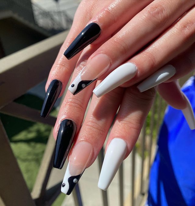 Chica mostrando sus uñas con diseño Yin Yang en color blanco con negro