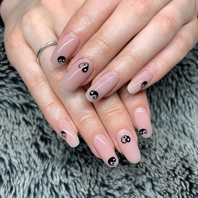 Chica mostrando sus uñas con diseño Yin Yang en color blanco con nude