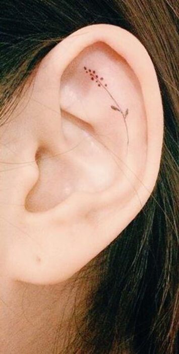 Chica con un tatuaje en la oreja en forma de pequeña flor