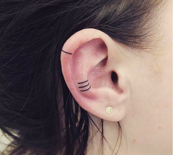 Chica con un tatuaje en la oreja que muestra líneas en diferentes ángulos
