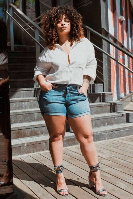 Chica usando unos mom shorts con camiseta de vestir y sandalias de tacón