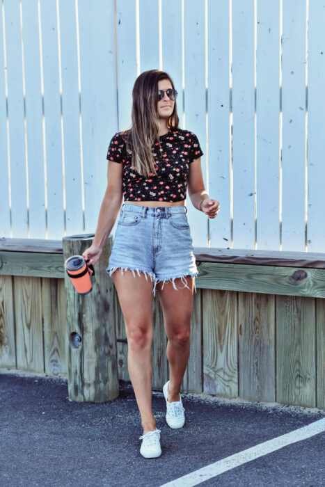 Chica usando unos mom shorts con blusa y tenis