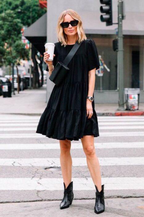 Chica con vestido negro y botas vaqueras