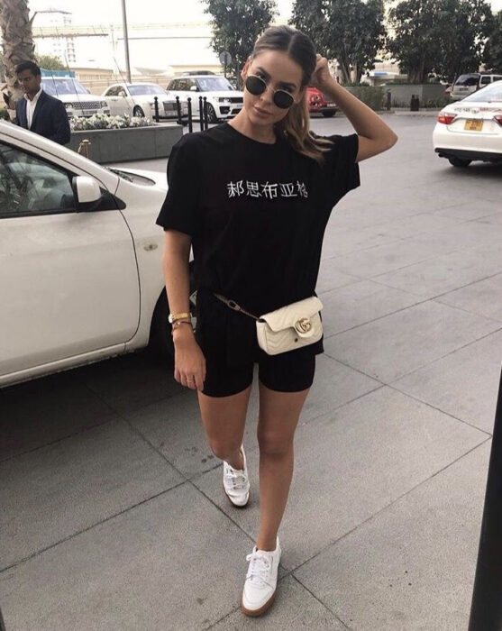 Chica con bike shorts, camisa larga y zapatos blancos
