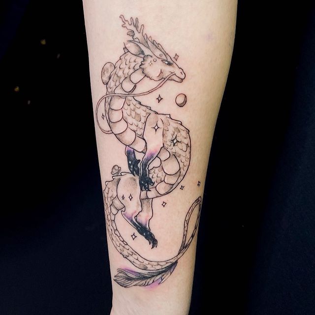 Tatuaje de dragón en estilo chibi en tonos negro y morado; 13 Tatuajes para convertirte en la nueva Daenerys Targaryen, madre de dragones
