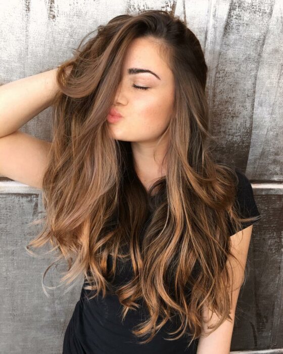 Chica mostrando su cabello teñido en color caramelo