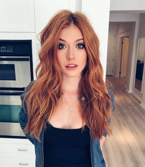 Chica mostrando su cabello teñido de un color cobrizo naranja