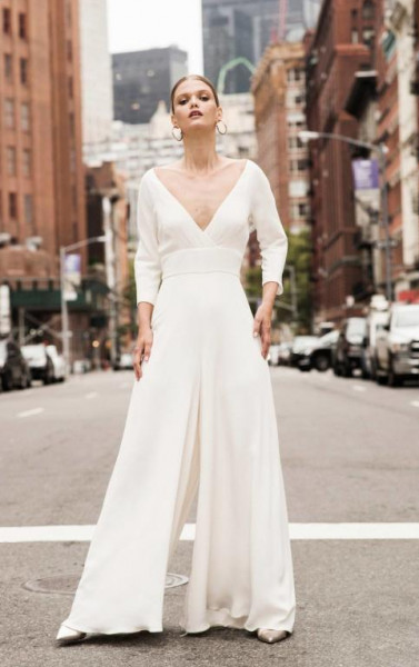 Chica usando un jumpsuit de color blanco con piernas anchas 
