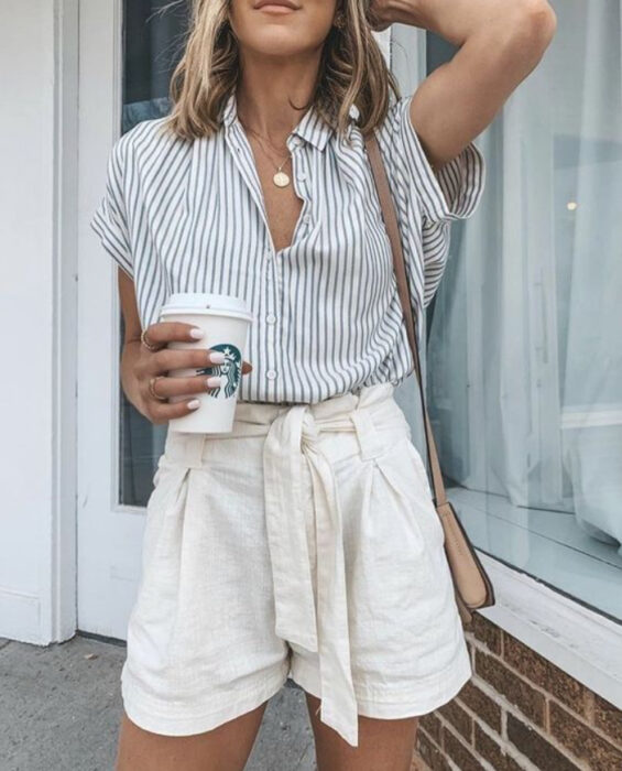 Chica usando camisa blanca con rayas azules y short blanco