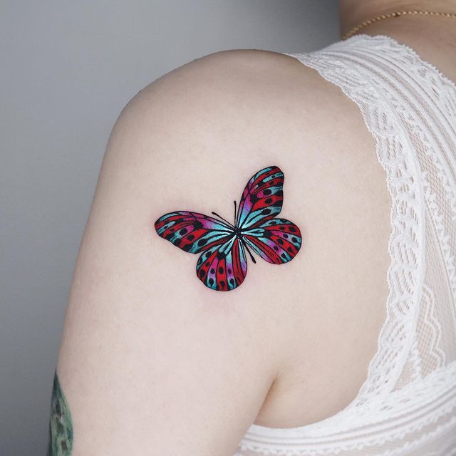 Tatuaje de mariposa en tono fucsia y verde; 15 Bellos tatuajes con mariposas para iniciar una metamorfosis