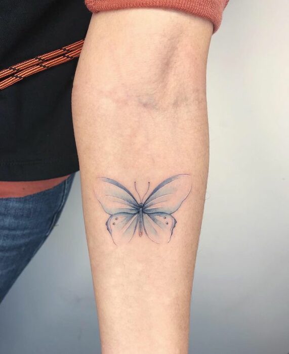 Tatuaje de mariposa en color azul con silueta degradada; 15 Bellos tatuajes con mariposas para iniciar una metamorfosis