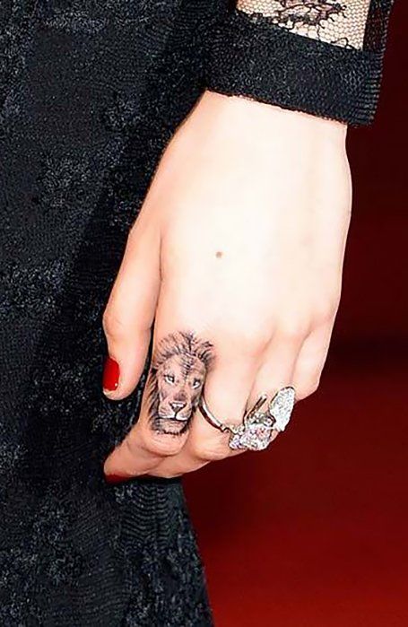 Chica con un tatuaje en forma de león en el dedo índice
