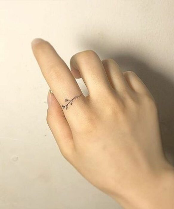 Chica con un tatuaje en forma de ramas en el dedo índice
