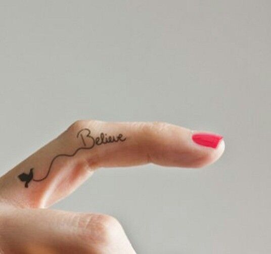 Chica con un tatuaje con una leyenda en el dedo medio
