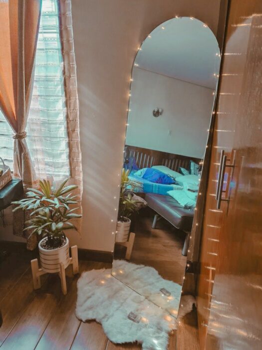 Rincón de una habitación decorado con un espejo de cuerpo completo