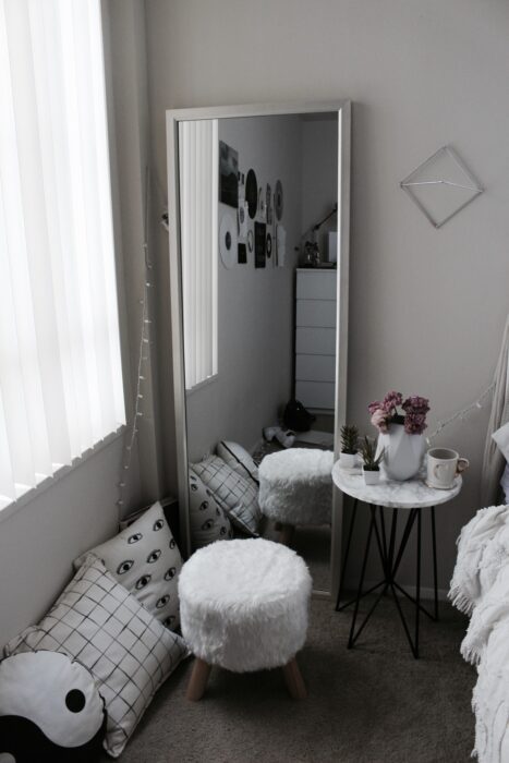 Rincón de una habitación decorado con un espejo de cuerpo completo