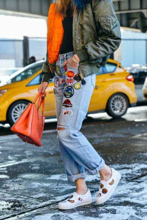 Chica llevando jeans rotos con parches decorativos; 13 Maneras de salvar tus jeans rotos y seguir a la moda