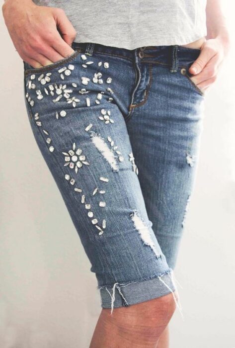 Chica llevando bermuda denim con decoraciones de piedras; 13 Maneras de salvar tus jeans rotos y seguir a la moda