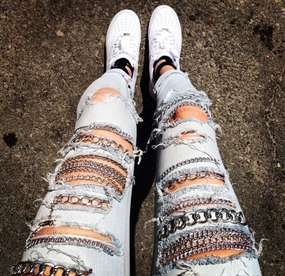 Chica llevando jeans rotos con cadenas decorativas; 13 Maneras de salvar tus jeans rotos y seguir a la moda