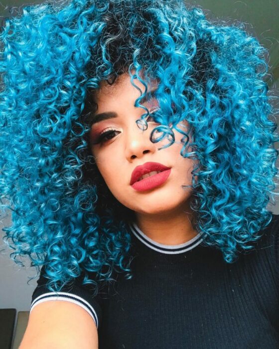 Chica con cabello rizado teñido en color aguamarina
