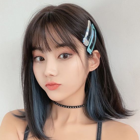 Chica con cabello corto y mechas bajas en tono azul cielo