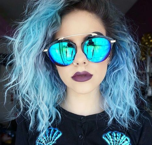 Chica con cabello ondulado teñido en tono azul agua