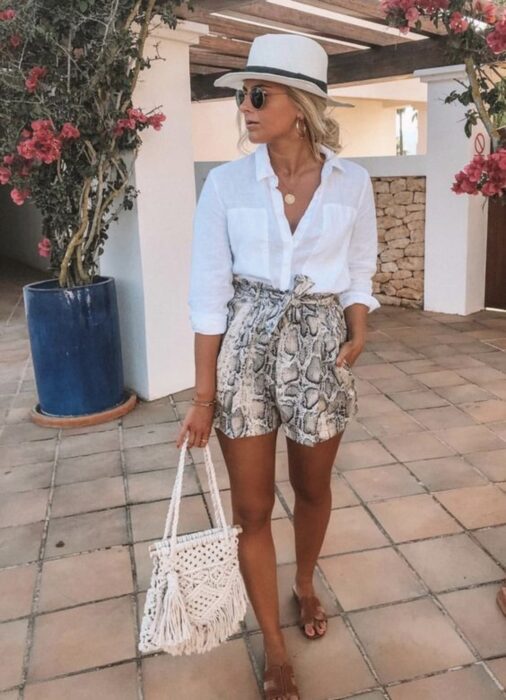 Chica en un outfit de playa con sombrero y accesorios blancos