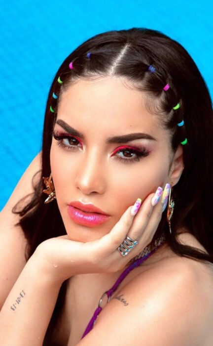 Kimberly Loaiza posando para una fotografía mientras usa liguitas para el cabello
