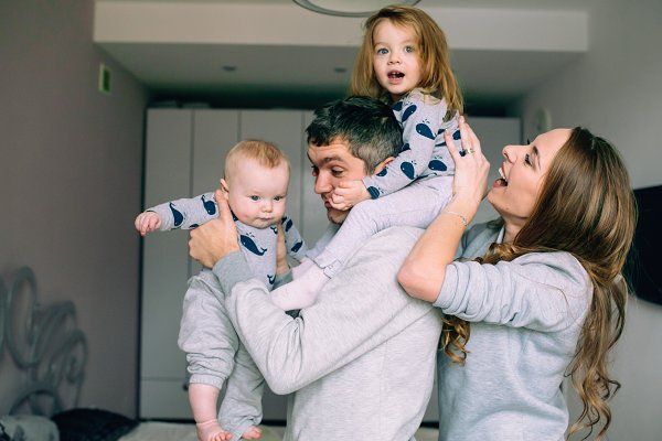 Papá y mamá jugando con sus bebés en la cocina