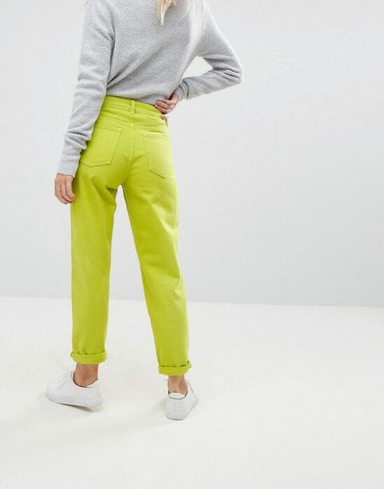 Chica usando mom jeans en color amarillo neón