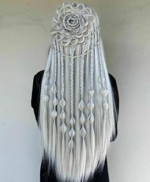Chica con el cabello trenzado de diferentes maneras y teñido de color platinado