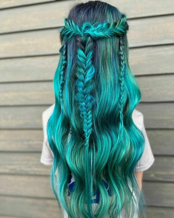 Chica con el cabello teñido de verde y trenzado de diferentes maneras