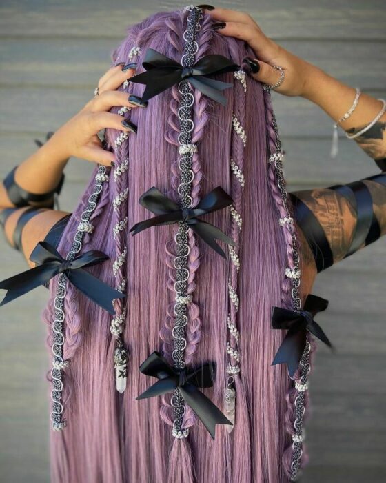 Chica con el cabello morado y trenzado con moños