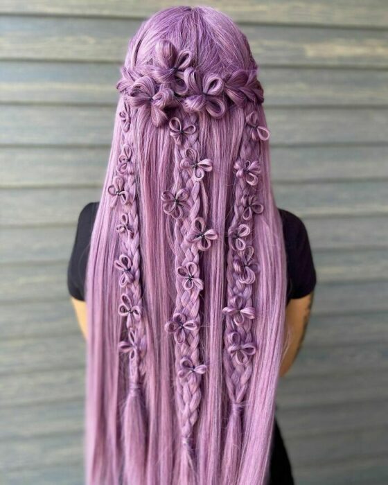 Chica con el cabello morado y peinado con varias trenzas