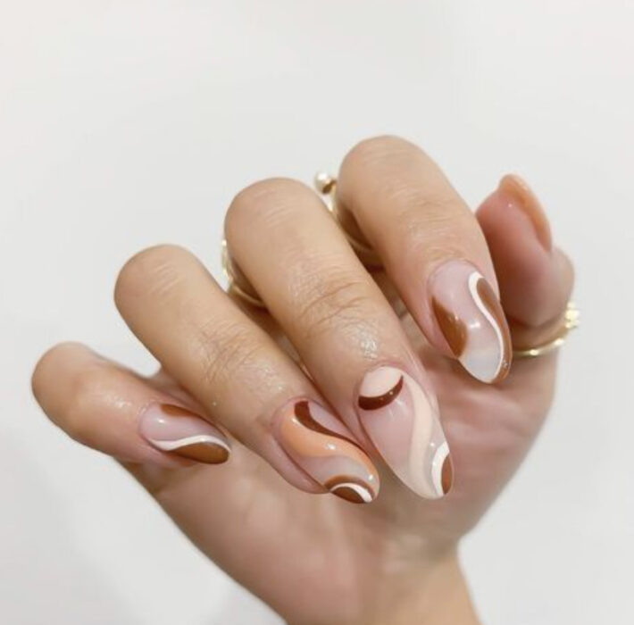 Manicura con base nude y líneas en diferentes tonos de café y degradado