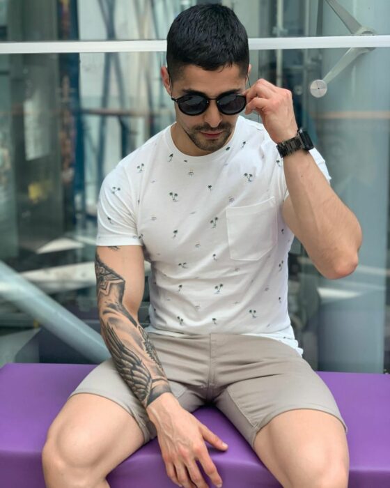 Chico posando para una fotografía mientras apoya su mano en un escritorio