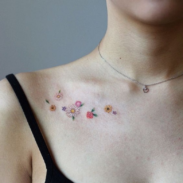 Tatuaje de flores sueltas de diferentes tipos, sobre las clavículas