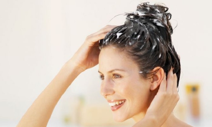 Chica aplicándose mascarilla capilar