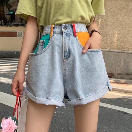 chica llevando short corto con bolsillos pintados en amarillo y verde