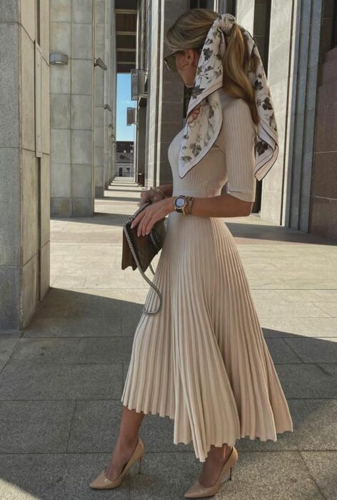 Victoria Fox usando vestido de vuelo nude con pañuelo en el cabello y bolsa negra