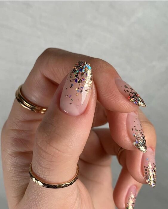 Uñas acrílicas transparentes con puntas decoradas con brillitos azules