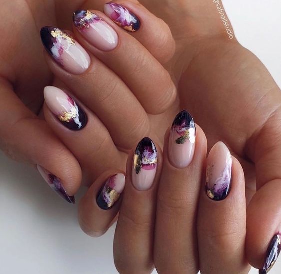Uñas cortas con forma de almendra decoradas en dorado y negro